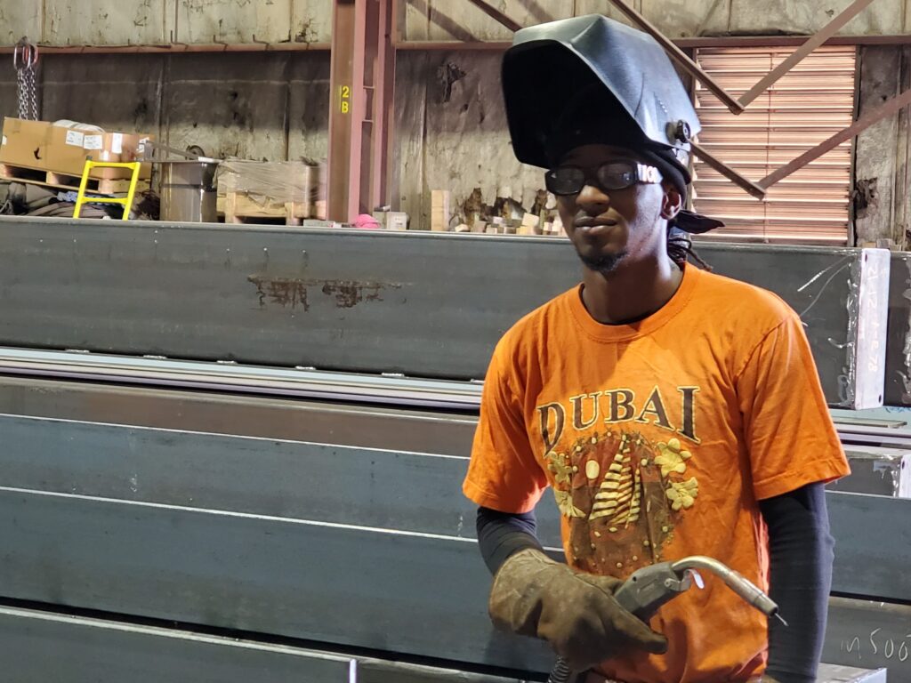 Stacey Gray stands in front of steel beams.