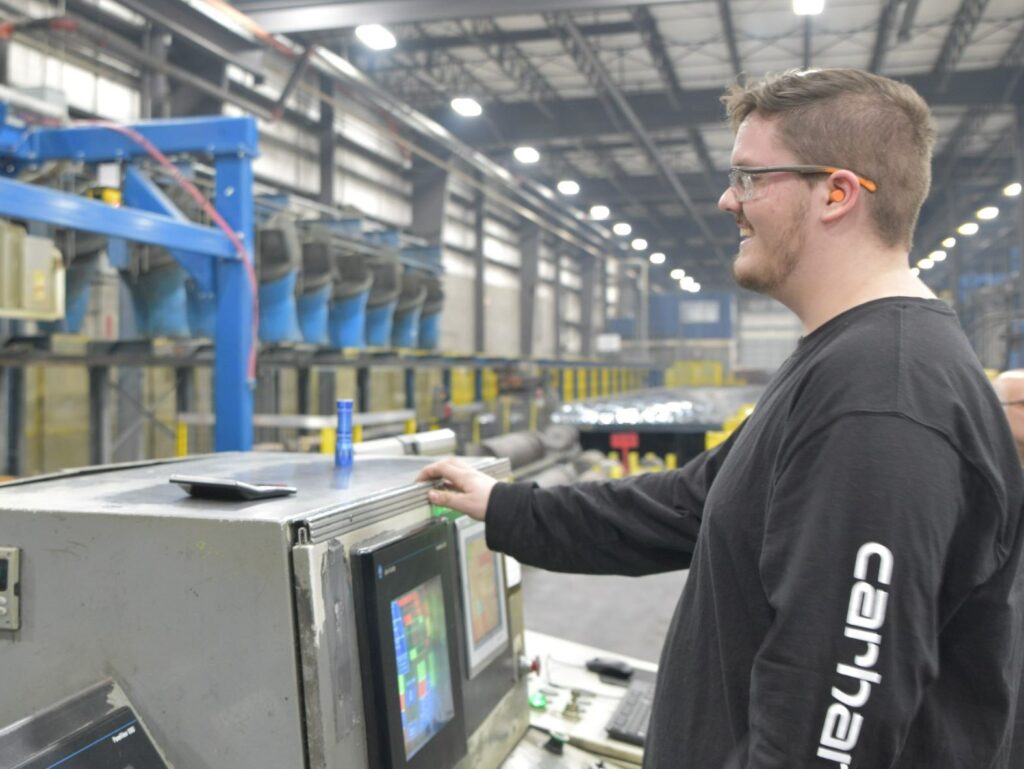 Employee works machine at Extrudex.