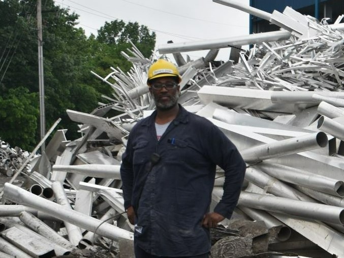 Bernard Jones Jr. stands in front of scrap aluminum.